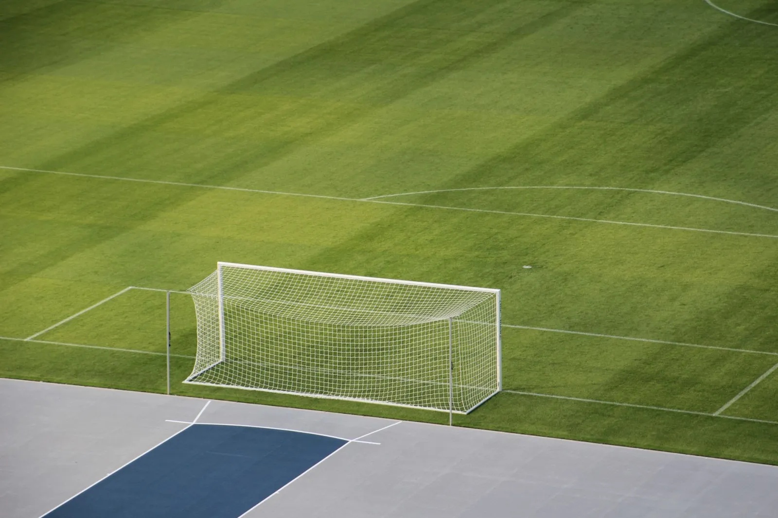 Aerial view of an empty soccer field showcasing the goal and green grass.